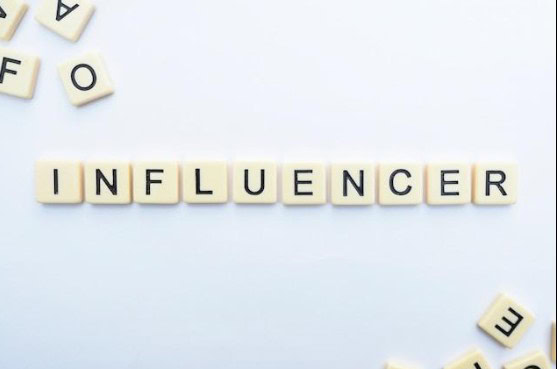  Letter blocks spelling out the word “influencer” on a white surface. 